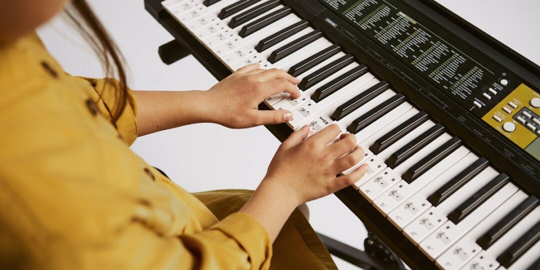 Teclado para produção musical: como escolher o melhor? 2 Jovem aprendendo a tocar teclado em casa